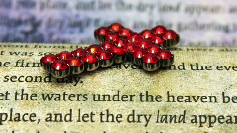 Red Cross Pendant on Bible Scripture Symbolizing Christian Faith and Spirit.. Видео 337435155