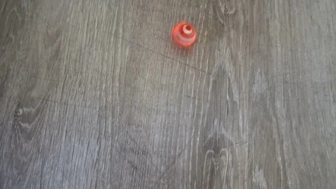 A red cube spinning on grey laminate Slow motion Stock Footage 76377442