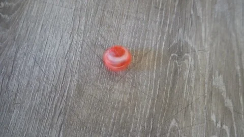 A red cube spinning on grey laminate Slow motion Stock Footage 76378055