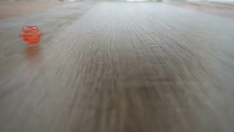 A red cube spinning on grey laminate Video stock 76378267