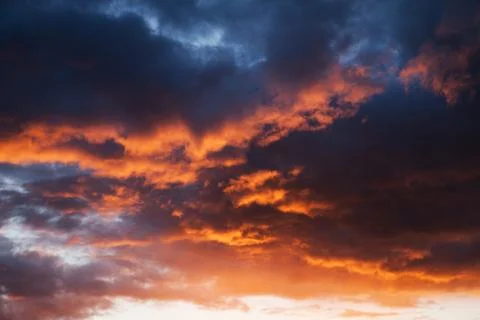 Red cumulus clouds illuminated by the setting sun in the evening Stock Photos