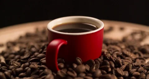 Red Cup with Black Coffee and scattered coffee beans rotating Stock Footage 98266902
