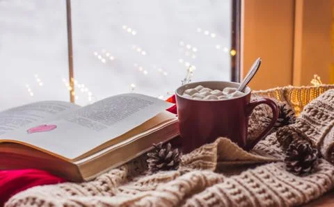 Red Cup with cocoa and marshmallows on a wooden table with scarves old book h Foto stock