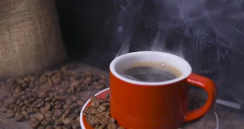 Red cup of coffee with coffee beans on dark textured background. Stock Footage 145154460