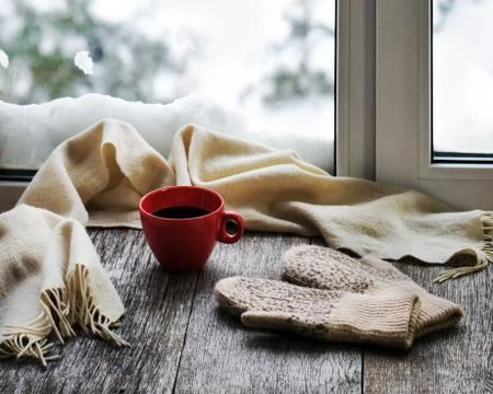 Red cup of coffee or tea, beige scarf and womans mittens. Stock Photos