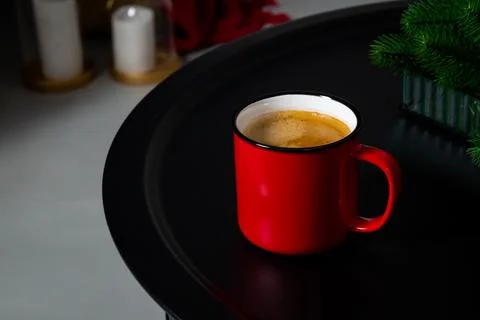 A red cup of coffee stands on the table. Cozy Christmas interior. Stock Photos