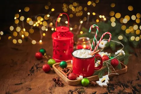 Red cup of hot cocoa with marshmallows and candy canes on wooden table with.. Fotos Stock