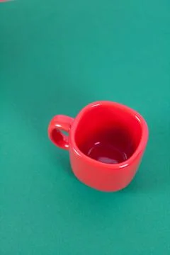 Red cup lying on a green background Stock Photos