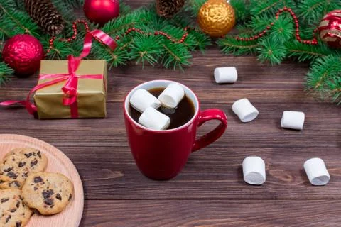 Red cup of tea with white marshmallows with cookies on a wooden table against Stock Photos
