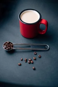 Red cup withe coffee and silver spoon with coffee beans Stock Photos