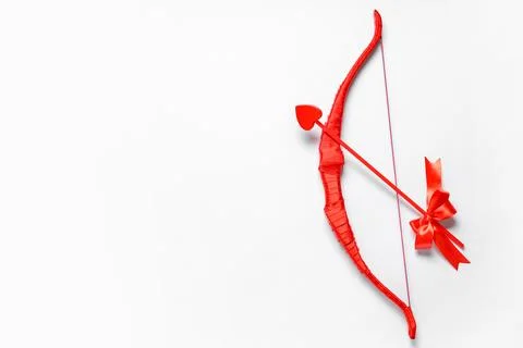 Red cupid's bow with arrow on light background. Valentine's Day celebration Stock Photos