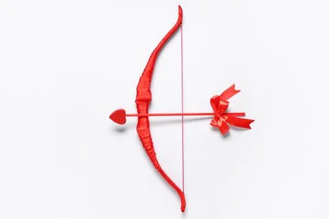 Red cupid's bow with arrow on light background. Valentine's Day celebration Stock Photos