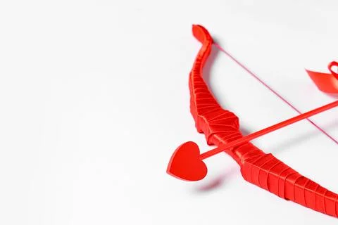 Red cupid's bow with arrow on light background. Valentine's Day celebration Stock Photos
