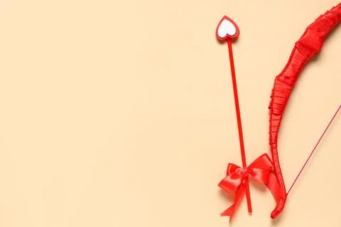 Red cupid's bow on color background. Valentine's Day celebration Stock Photos
