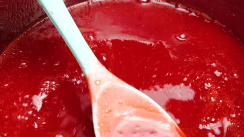 Red currant jam boils and bubbles intensely in a hot stainless steel pot.  스톡 동영상 337676521