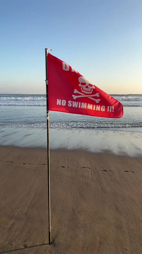 A red "Danger - No Swimming" flag on Seminyak beach, Bali, Indonesia, HD Stock Footage 319877611