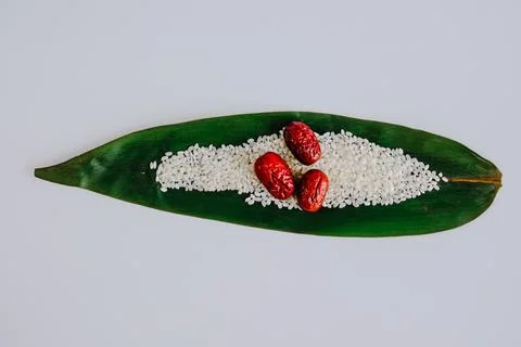 Red dates and white grains on green leaf Stock Photos