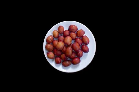 Red dates isolated on a ceramic plate Stock Photos