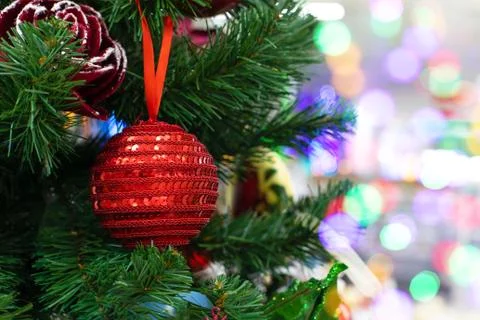 A red decorative ball made of shining lurex hanging on a branch of a Christma Stock Photos