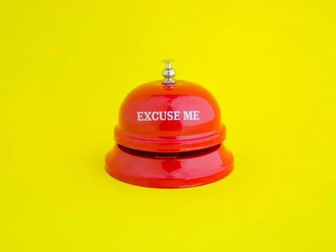 The red desktop bell has the message "Excuse me" placed on a bright yellow ba Foto stock