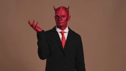 Red devil businessman with horns knocking himself on the head and shaking his Stock Footage 285383324
