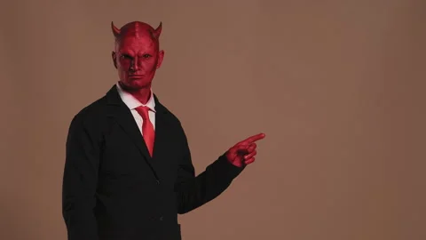 Red devil businessman pointing on brown background Stock Footage 300467401