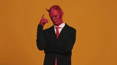 Red devil businessman thinking and touching his head on orange background Stock Footage 295142469