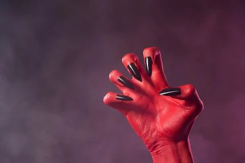 Red devil hand with black glossy nails 스톡 사진