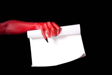 Red devil hand holding paper scroll Stock Photos