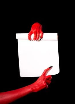 Red devil hands holding paper scroll Fotos de archivo