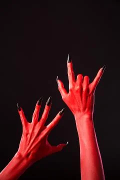Red devil hands with long black nails, real body-art Foto stock
