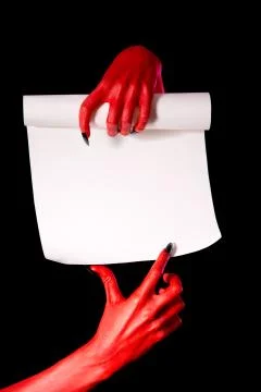 Red devil hands with paper scroll Foto stock