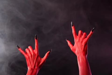 Red devil hands showing heavy metal gesture Stock Photos