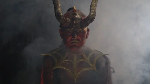 Red devil with horns is sitting in the smoke and looking with evil intent Stock Footage 115159056