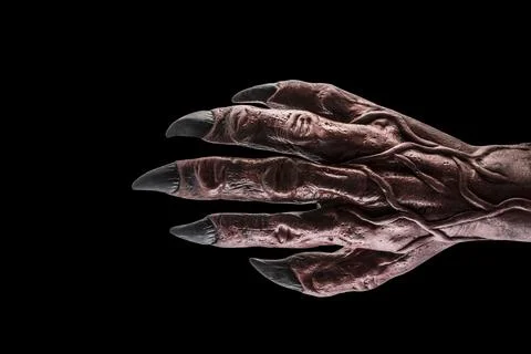 Red devil monster hand isolated on black background Foto stock