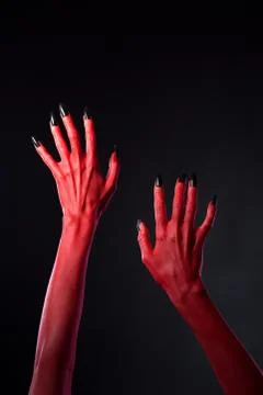 Red devilish hands with black nails, body-art Foto stock