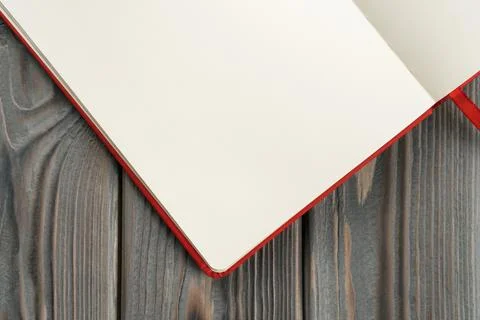 Red diary, notebook corner of white paper pages on dark wooden background Stock Photos