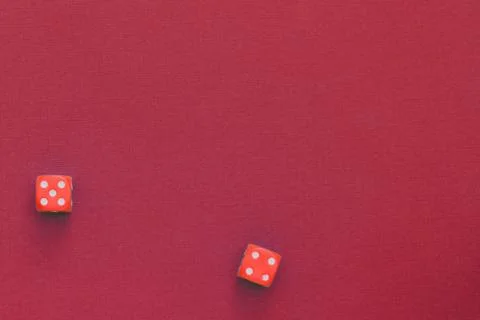 Red dice on a dark red background. Gambling concept, top view, copy space. Stock Photos