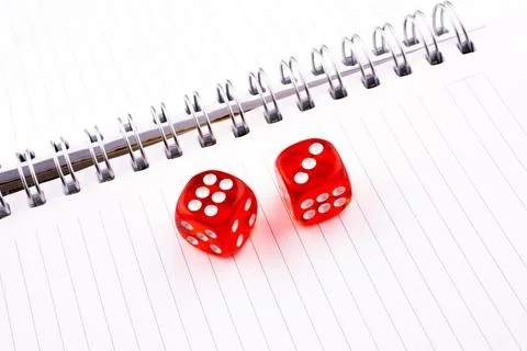 Red dice on a a notebook on a white background Foto stock