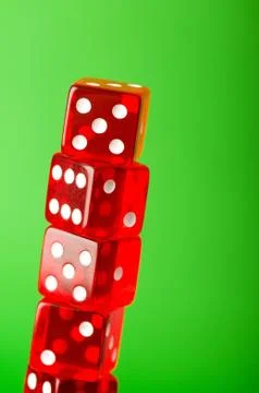 Red dice stack against blurred green background Stock Photos