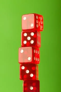 Red dice stack against blurred green background Stock Photos
