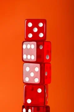 Red dice stack against orange background Stock Photos