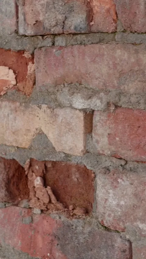 Red dilapidated bricks crumble in old wall with gray cracked cement seams. Stock Footage 263460526