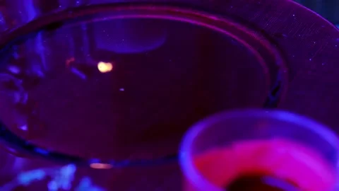 Red dish with water, reflections of lights of candles in liquid mysteriously  Stock Footage 207815511