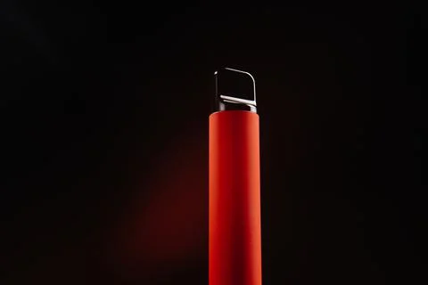 Red disposable e-cigarette on a dark background. Electronic vape, an alternative 库存照片