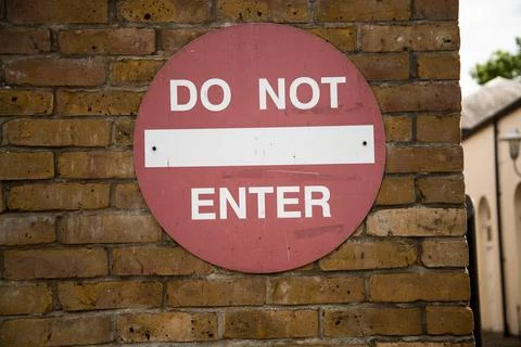 Red "DO NOT ENTER" sign mounted on a wall Stock Photos