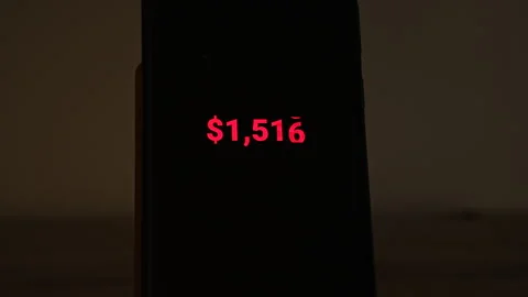 Red dollar amount counts down from 2,500 to zero on a smartphone standing in a Stock-Footage 347516580