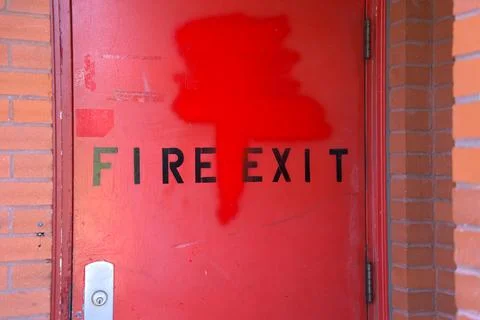 Red door labeled fire exit with a bold graphic design. Stock Photos