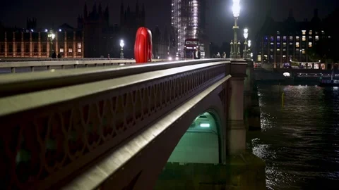 A Red Double Decker Bus drives along Westminster Bridge at night Stockbeeldmateriaal 164007101