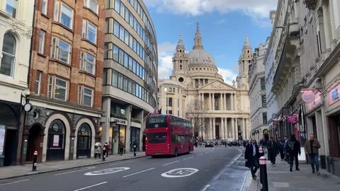 Red double decker bus driving on street towards St Pauls Cathedral in Stock Footage 236914453